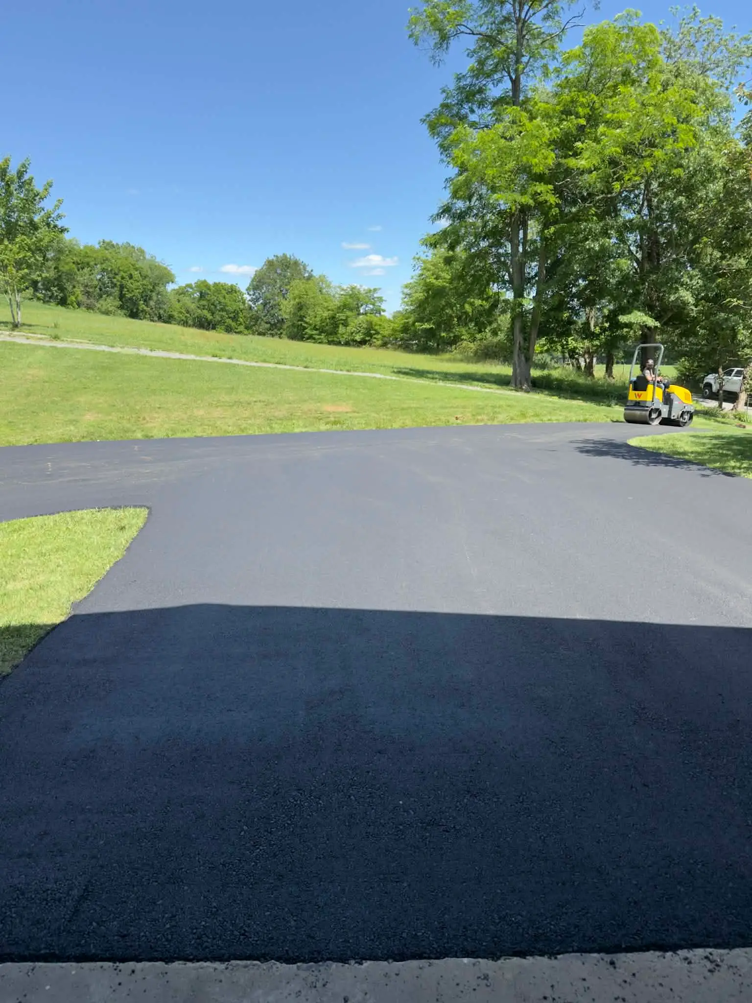 Lines by JD crew finishing a freshly paved asphalt driveway with a roller in Southwest Virginia