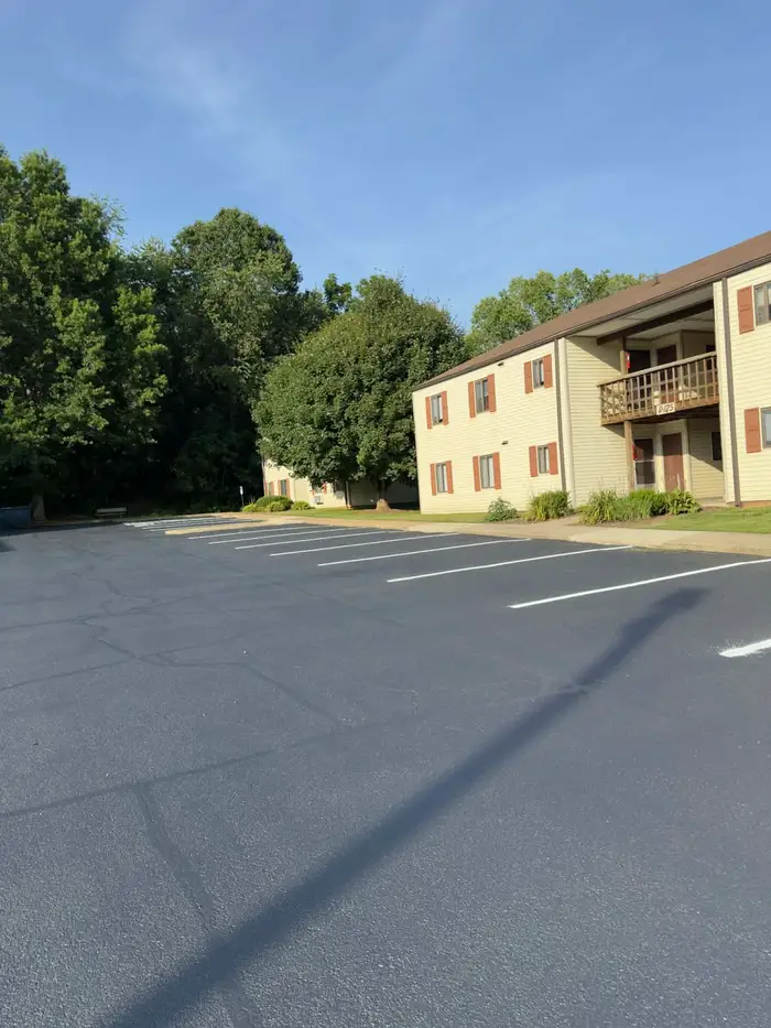 Sealed and re-striped parking lot at a two storey apartment building with red shutters